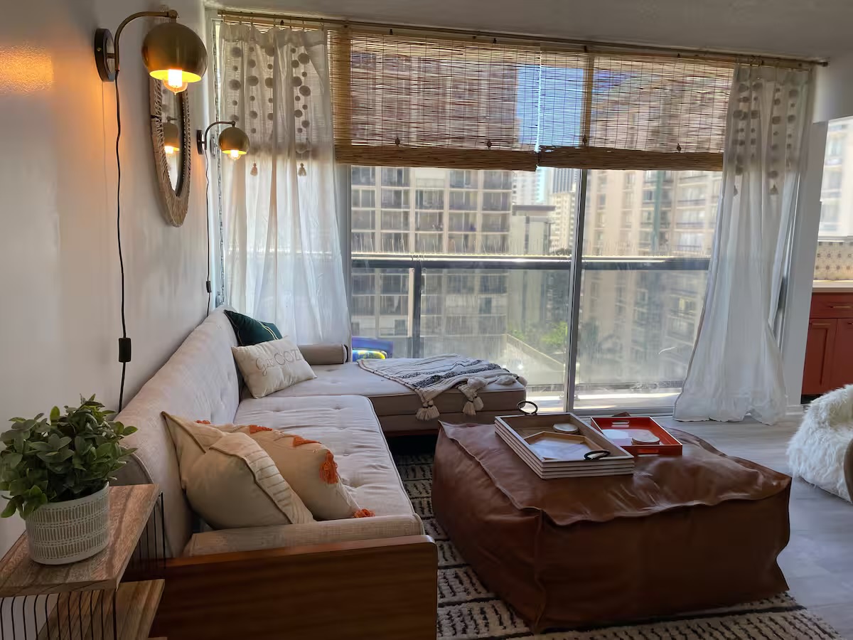 Living room with sectional couch, tiki lanterns, and skyline views