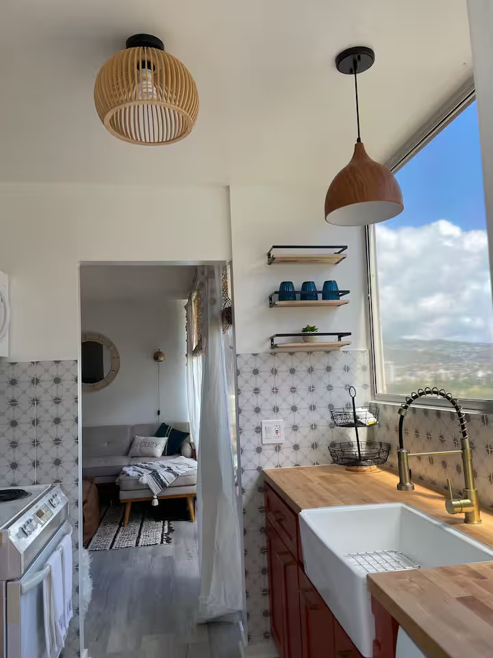 Kitchen with butcher-block counters, patterned tile, and mountain-facing window